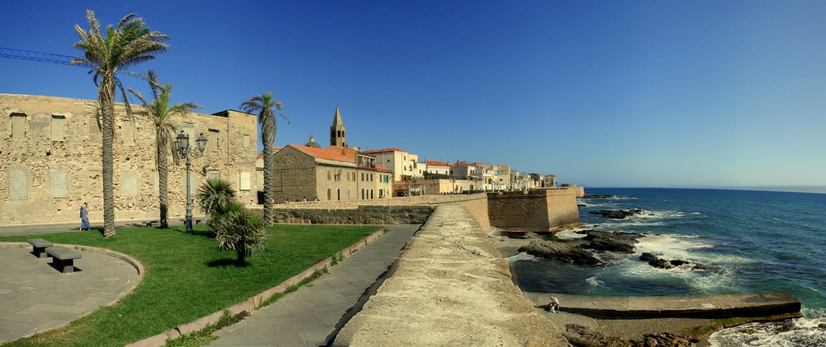 Bastioanele de pe mare ale orașului Alghero, cu clopotnița catedralei în spate.