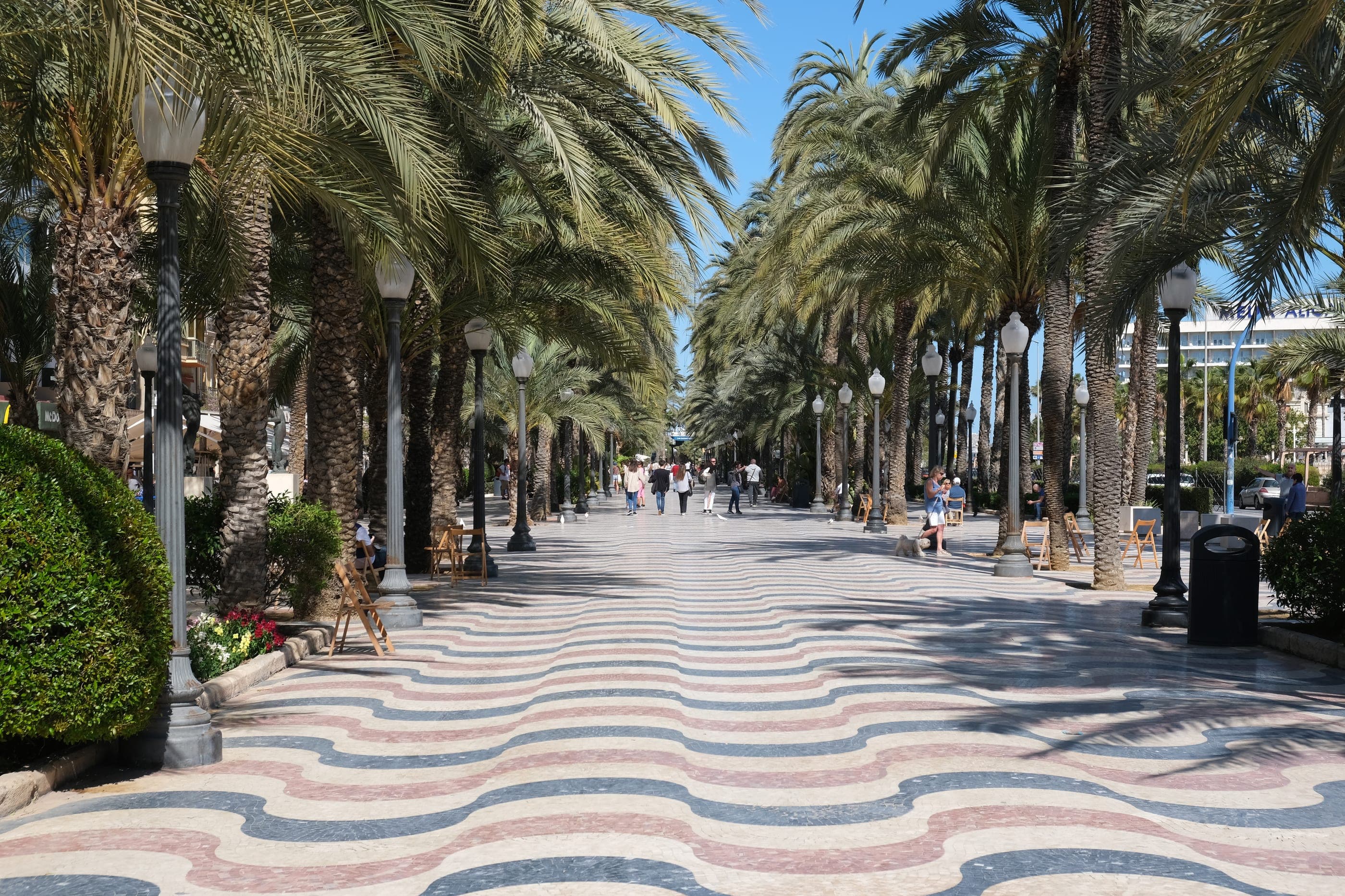 Explanada de España, cu palmieri și pavajul ondulat de marmură.