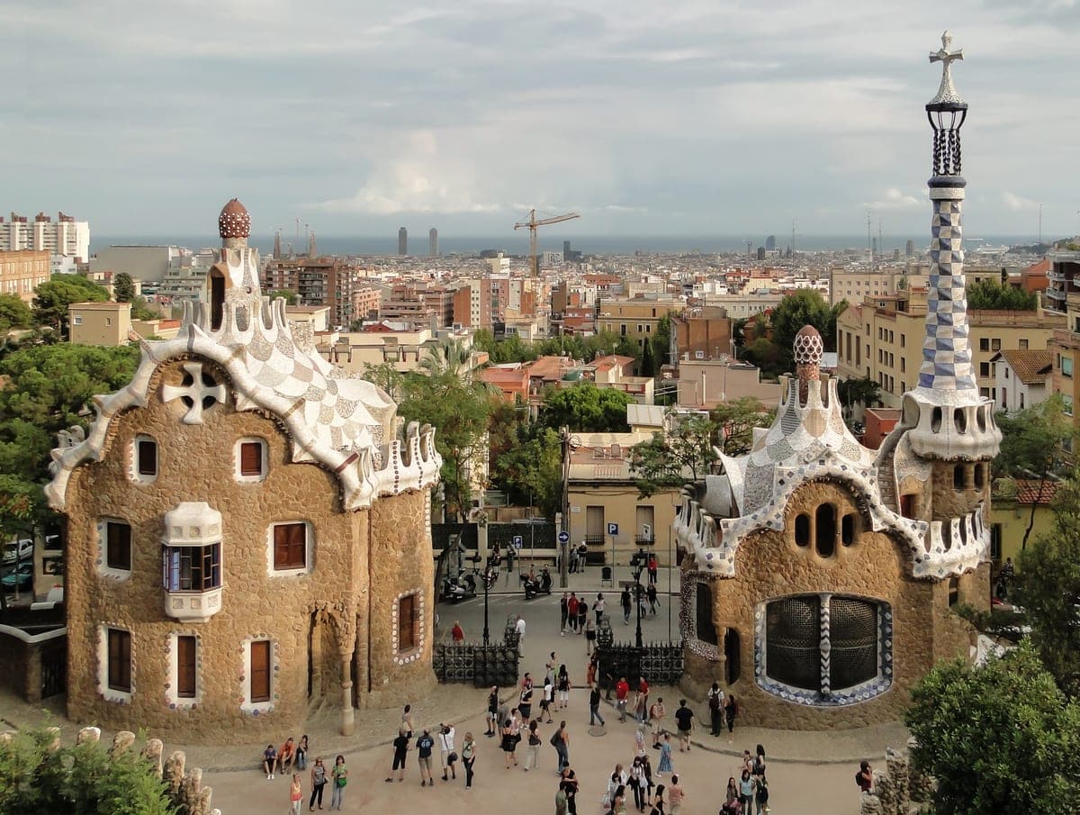 Pavilioanele lui Gaudí de la intrarea în Park Güell, cu orașul în spate.