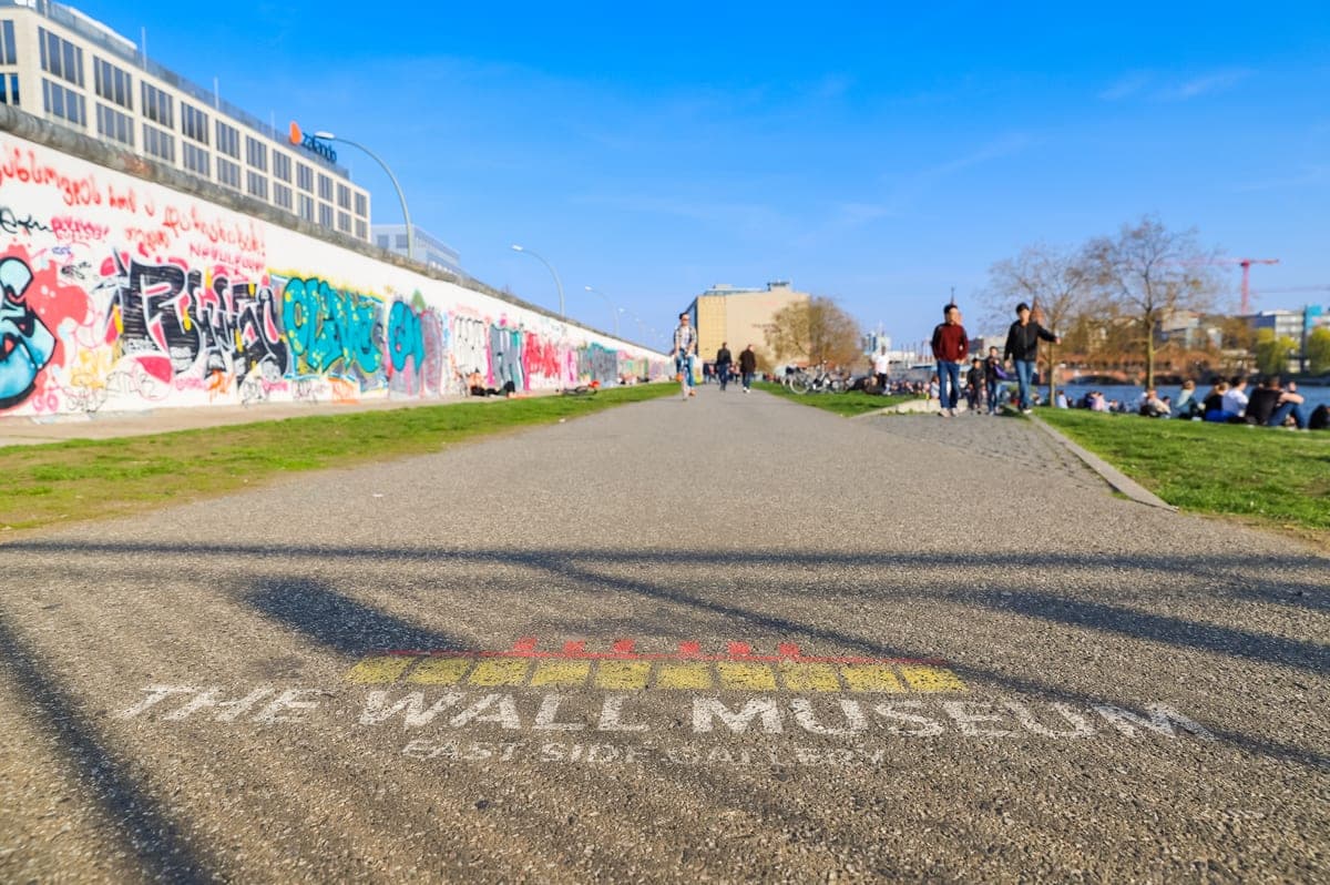 Zidul East Side Gallery văzut din parcul dintre Mühlenstraße și Spree.