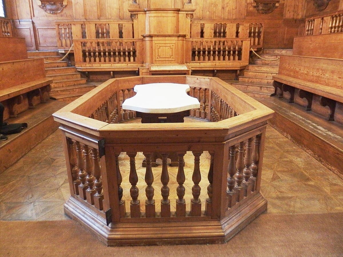 Interiorul de lemn al Teatrului Anatomic din Archiginnasio, cu masa de disecție în centru și băncile în trepte.
