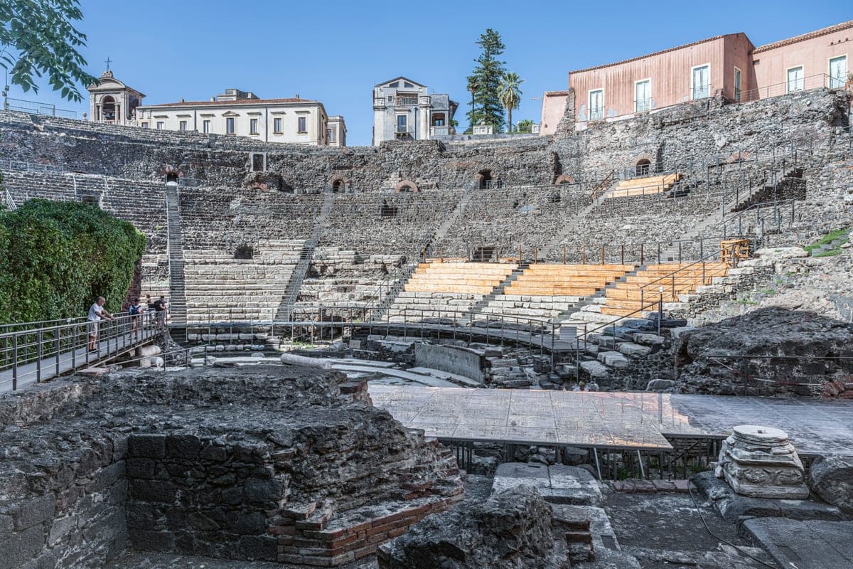 Gradenele Teatrului Roman din Catania, înconjurate de clădiri.