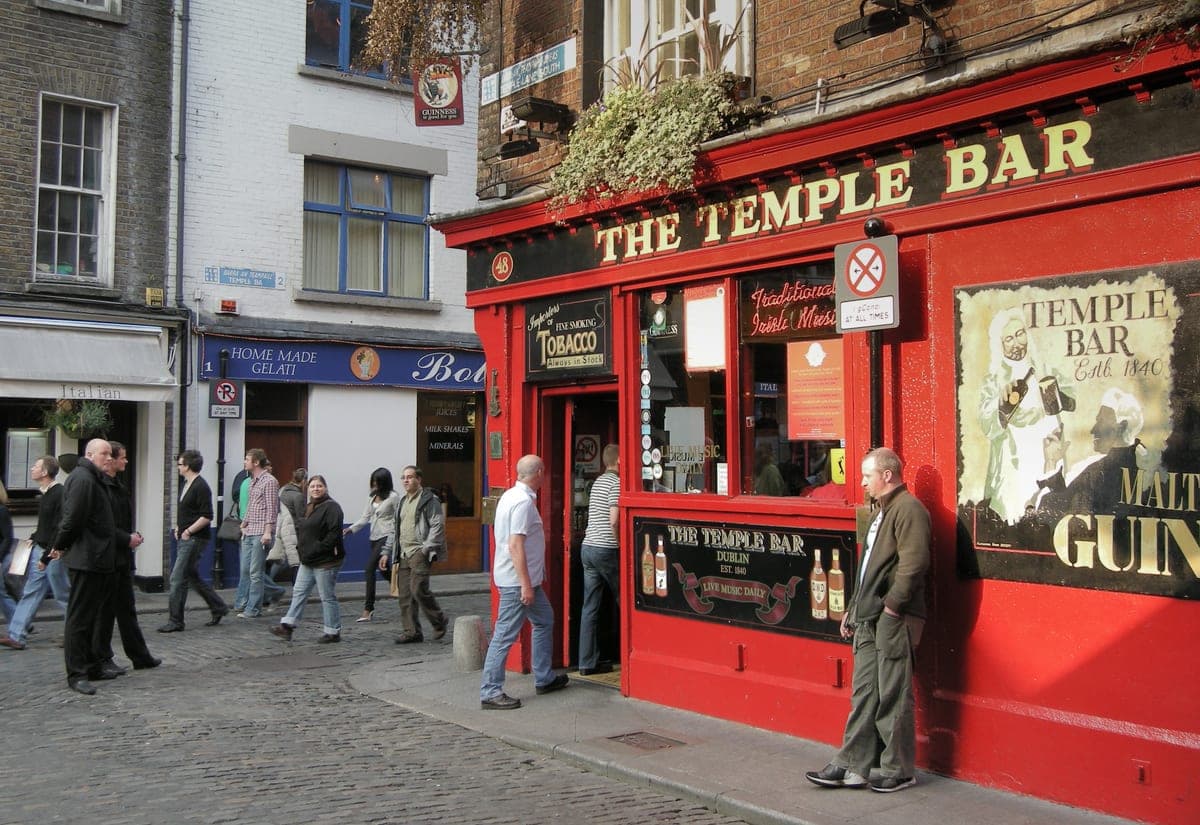 Pubul The Temple Bar, cu fațada roșie, pe o stradă pietruită.