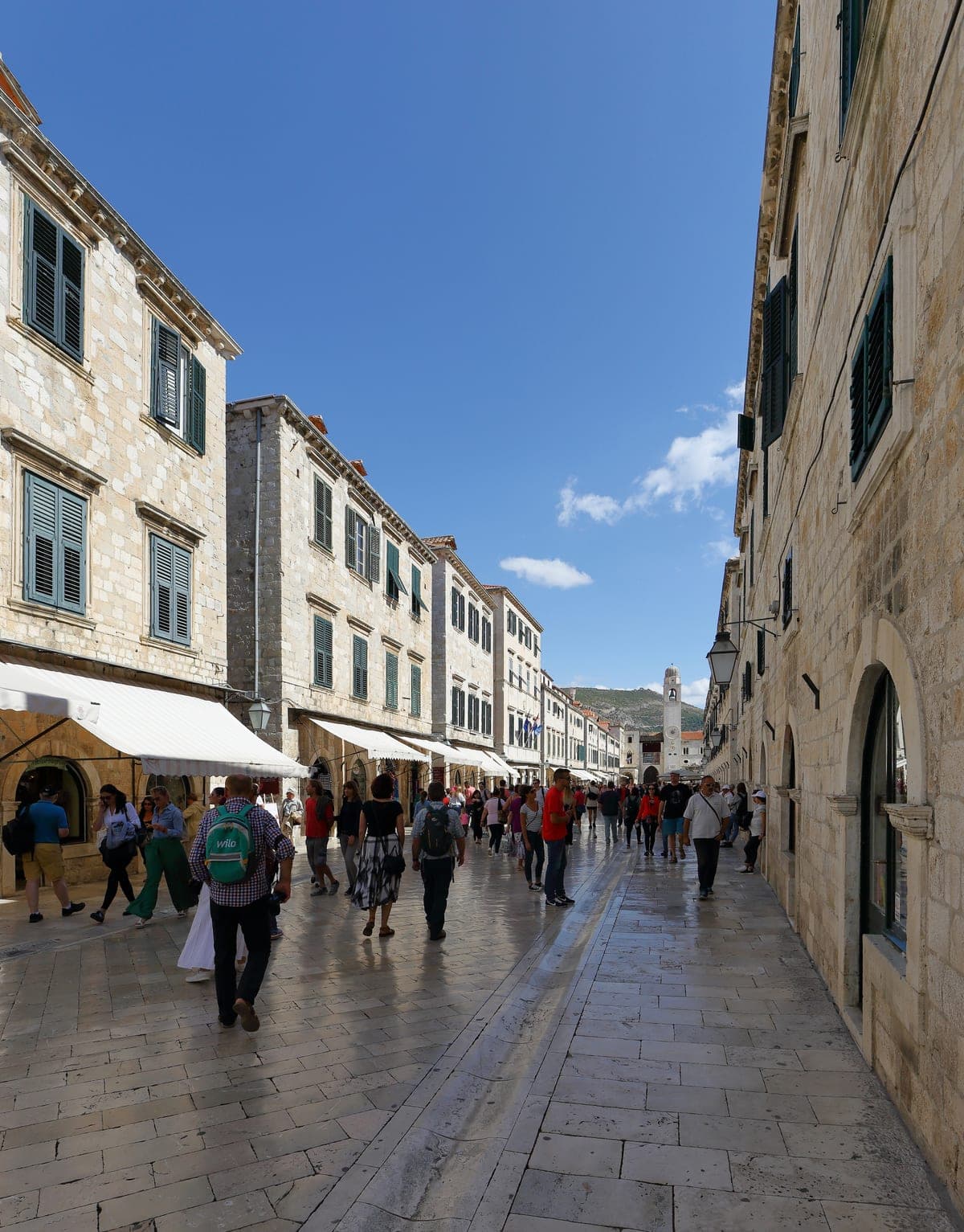 Stradunul din Dubrovnik, cu pavajul lustruit și casele de piatră de o parte și de alta.