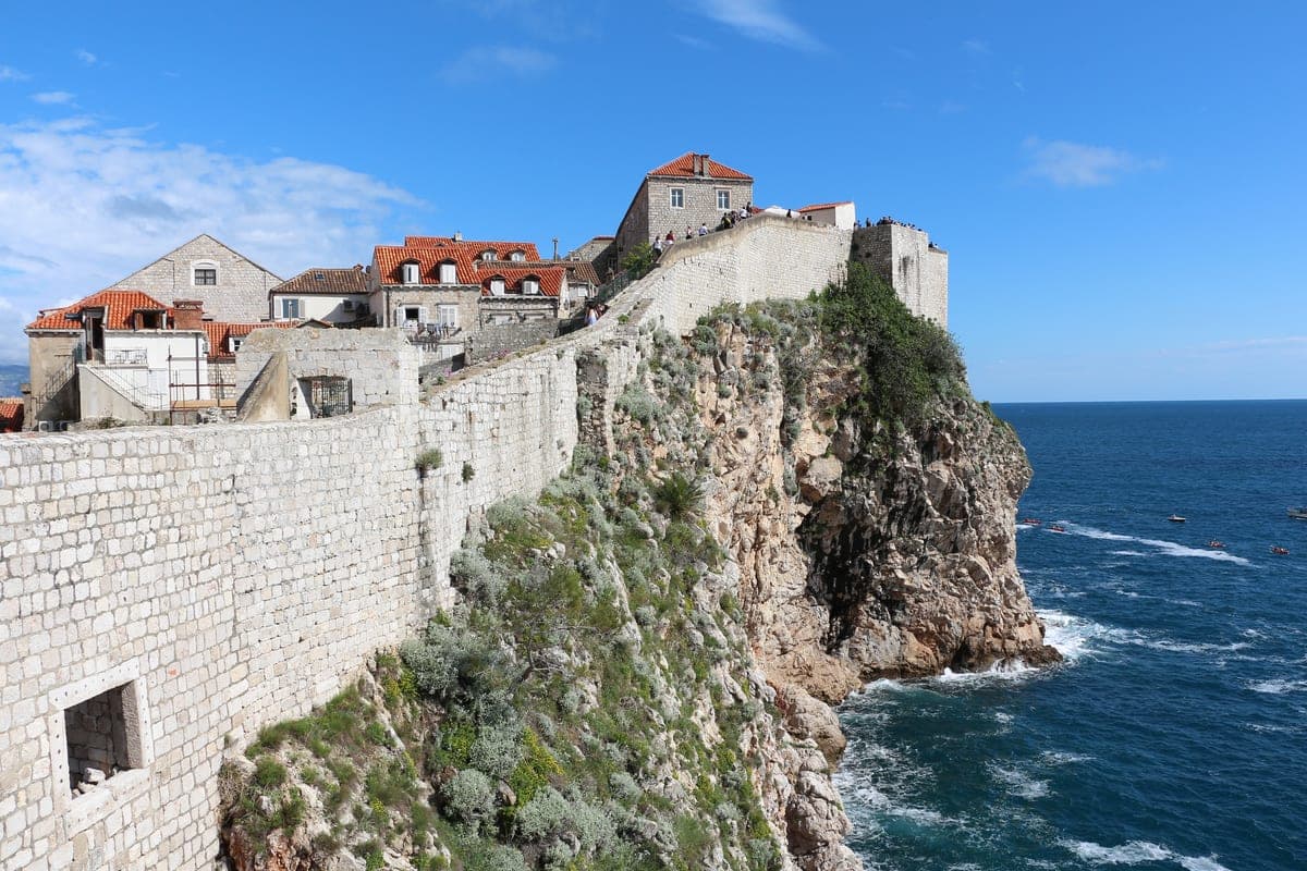 Zidurile Dubrovnikului deasupra mării, cu acoperișurile orașului vechi în spate.