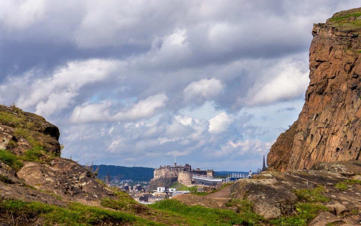Stâncile din Holyrood Park, cu castelul și orașul în depărtare.