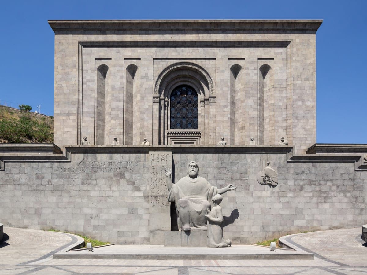 Fațada de piatră a Matenadaranului și statuia lui Mesrop Mashtots din fața ei.