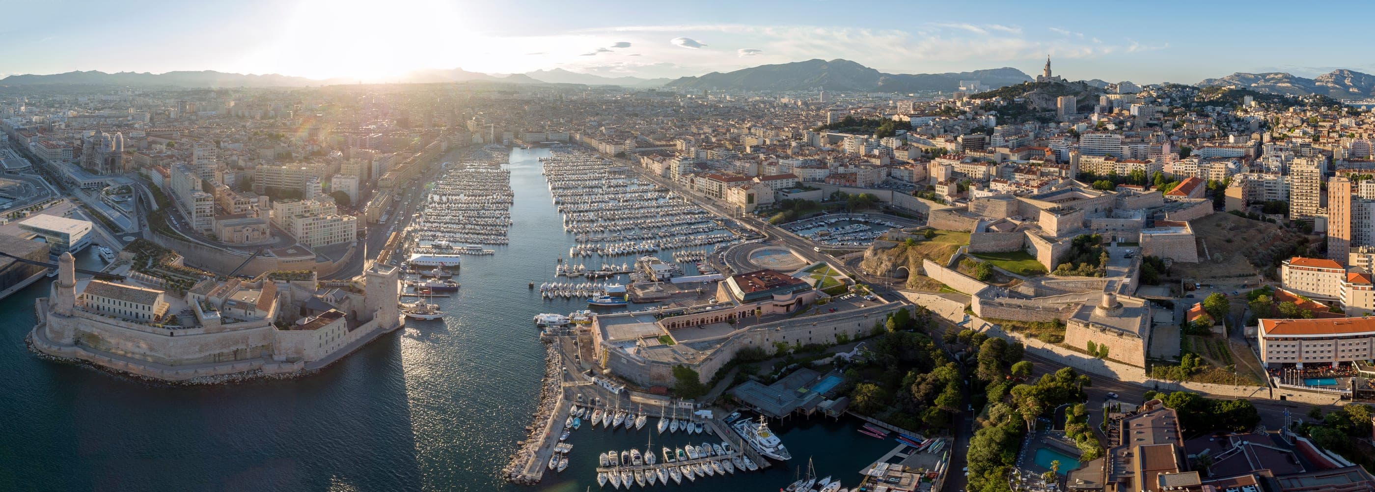 Portul vechi al Marsiliei văzut de sus, cu bazilica Notre-Dame de la Garde pe deal.