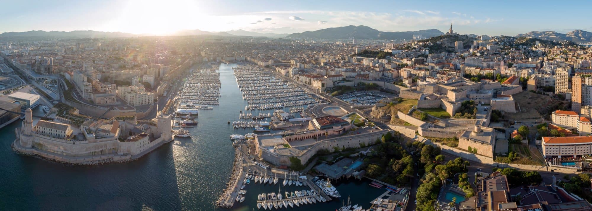 Portul vechi al Marsiliei văzut de sus, cu bazilica Notre-Dame de la Garde pe deal.