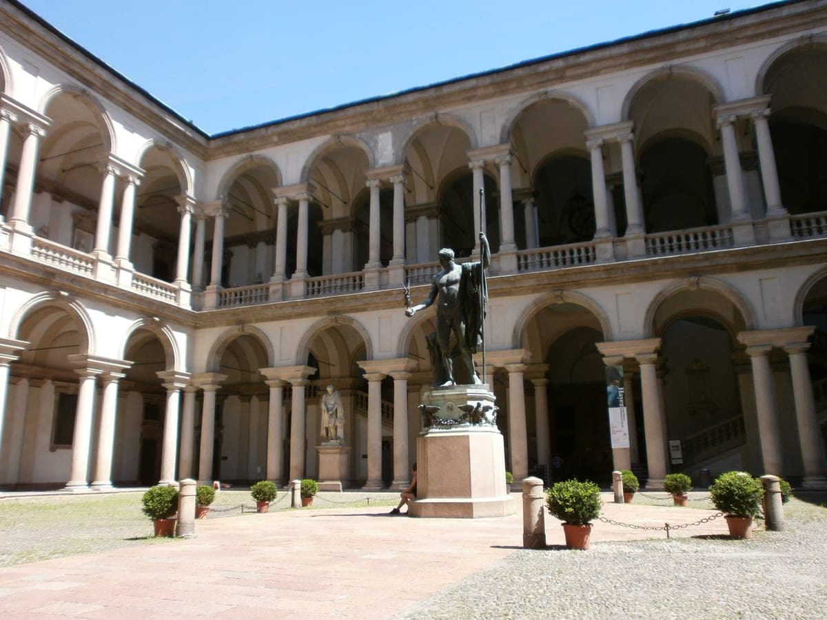 Curtea interioară a Palatului Brera, cu arcadele pe două niveluri şi statuia din centru.