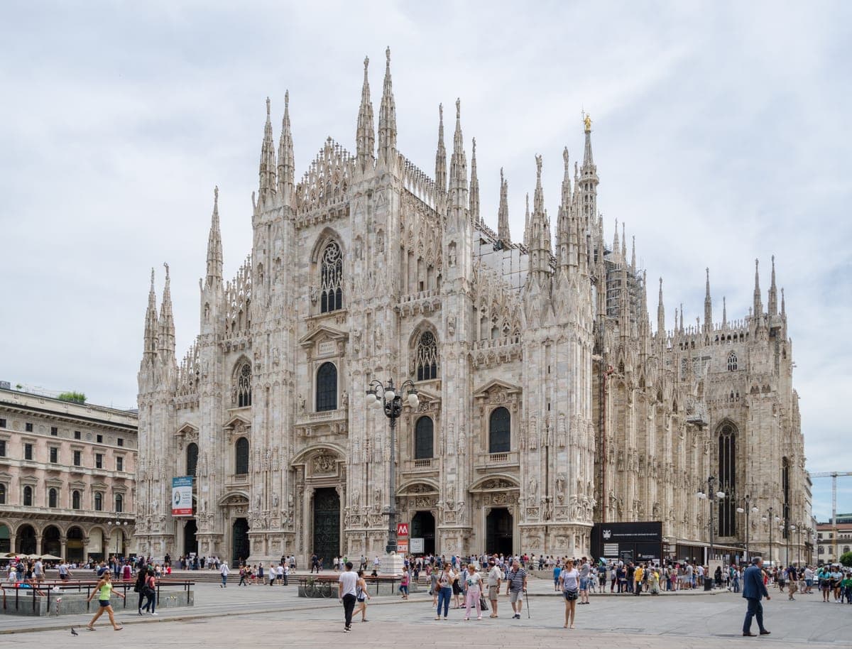 Faţada din marmură albă a Domului din Milano, văzută din piaţă, sub cer senin.
