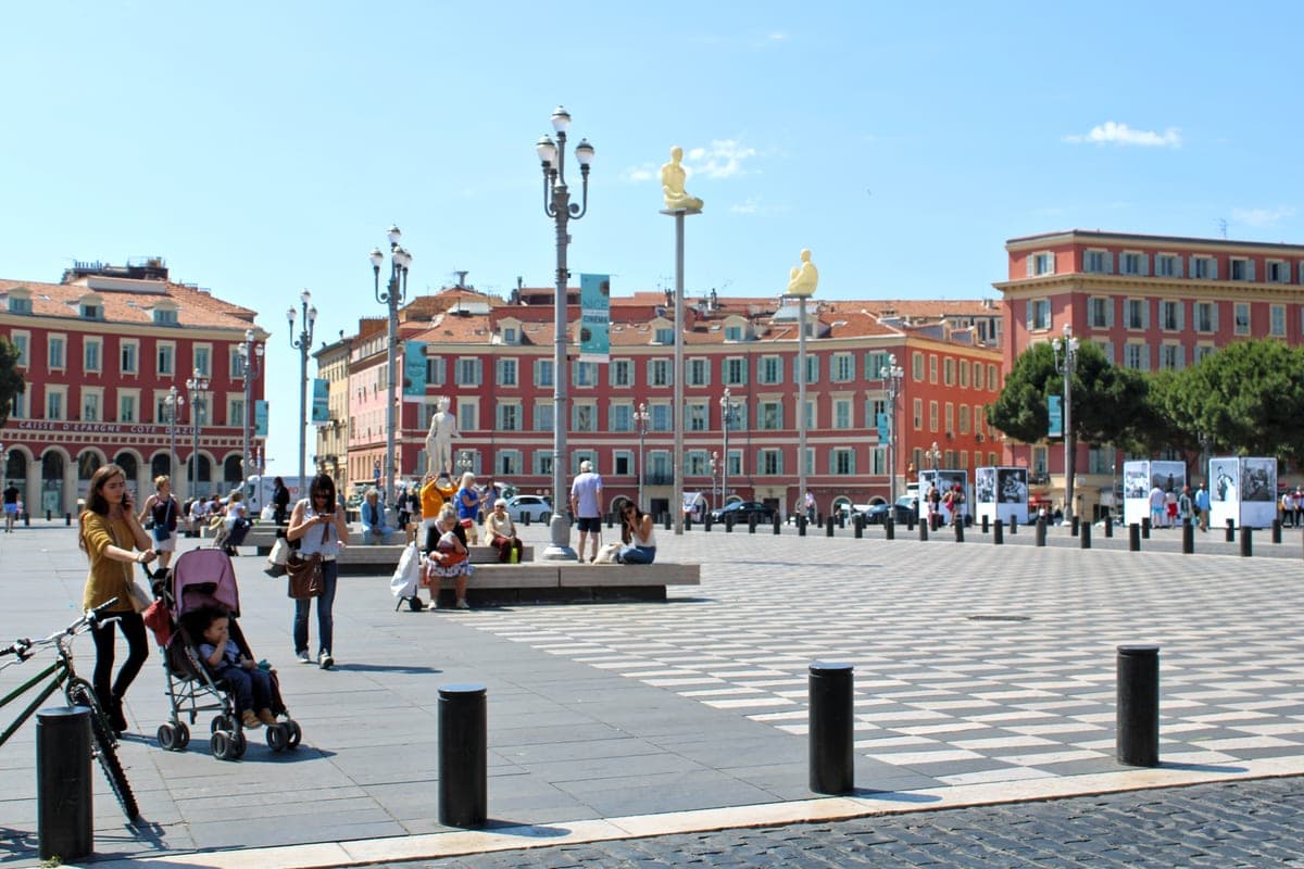 Place Masséna din Nisa, cu fațadele roșii și pavajul alb-negru.