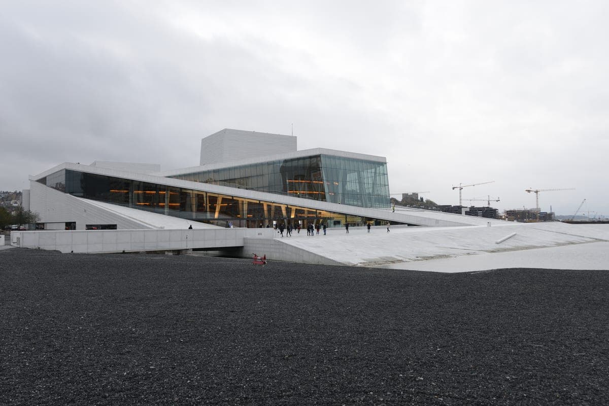 Opera din Oslo, cu acoperișul alb înclinat și fațada de sticlă.