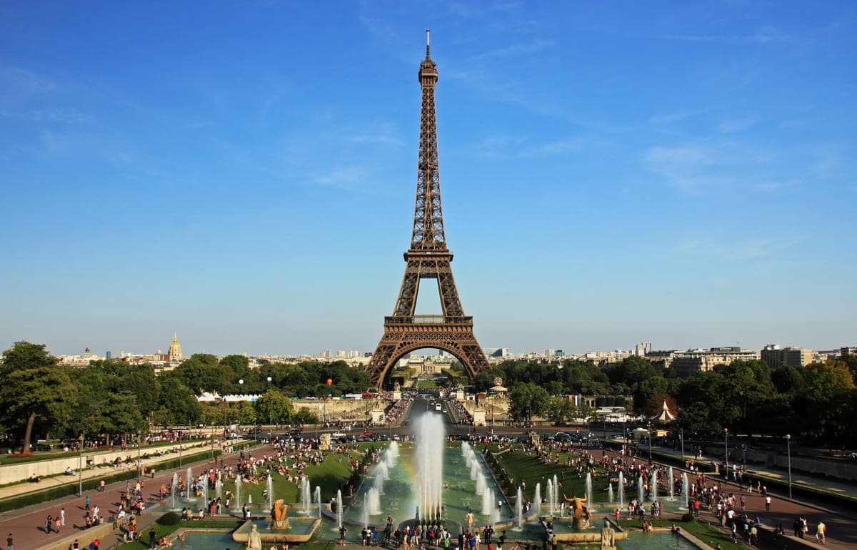 Turnul Eiffel ziua, văzut din grădinile Trocadéro, cu fântânile în prim-plan.