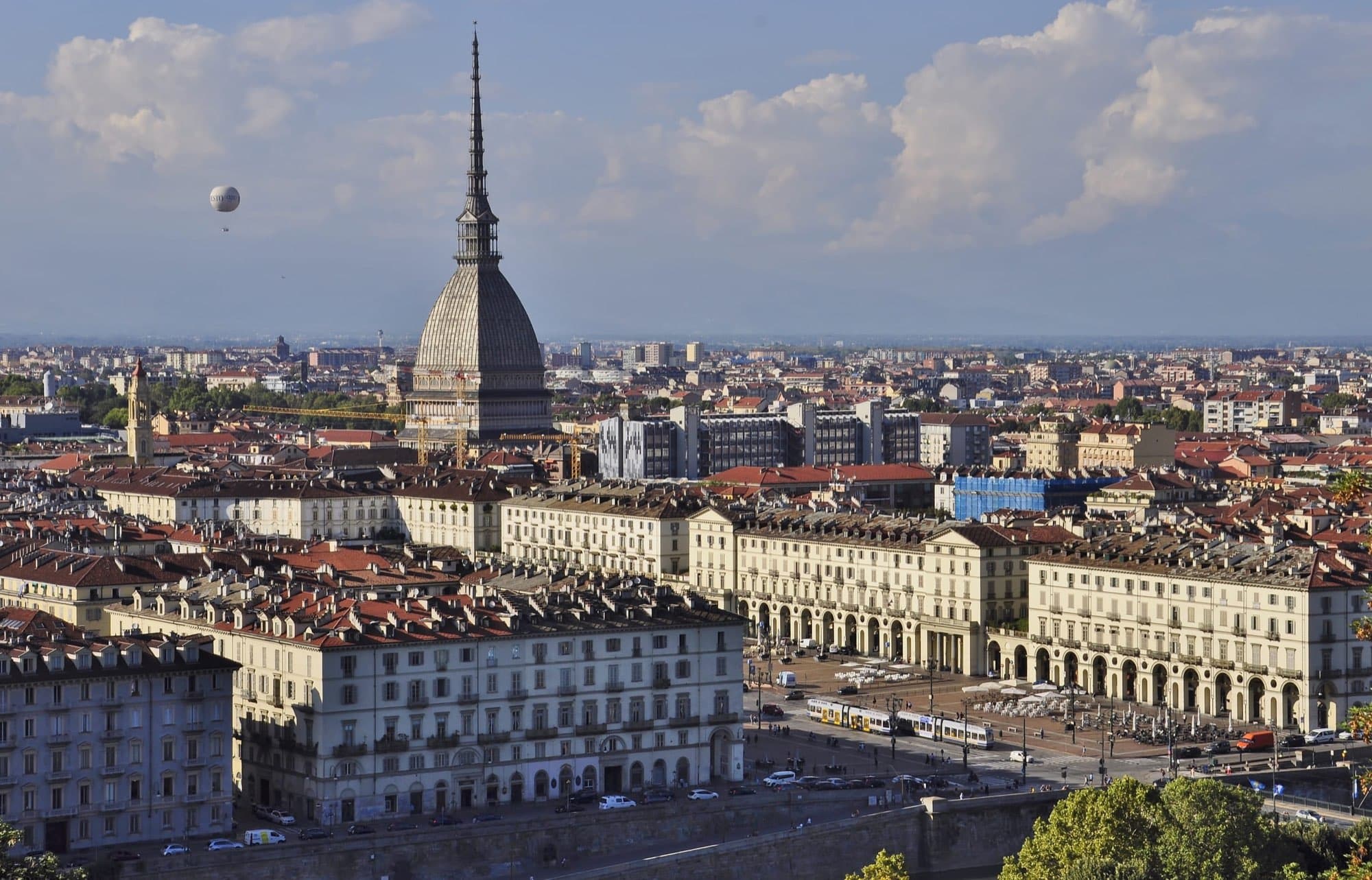 Mole Antonelliana deasupra acoperișurilor Torinoului, într-o zi însorită.