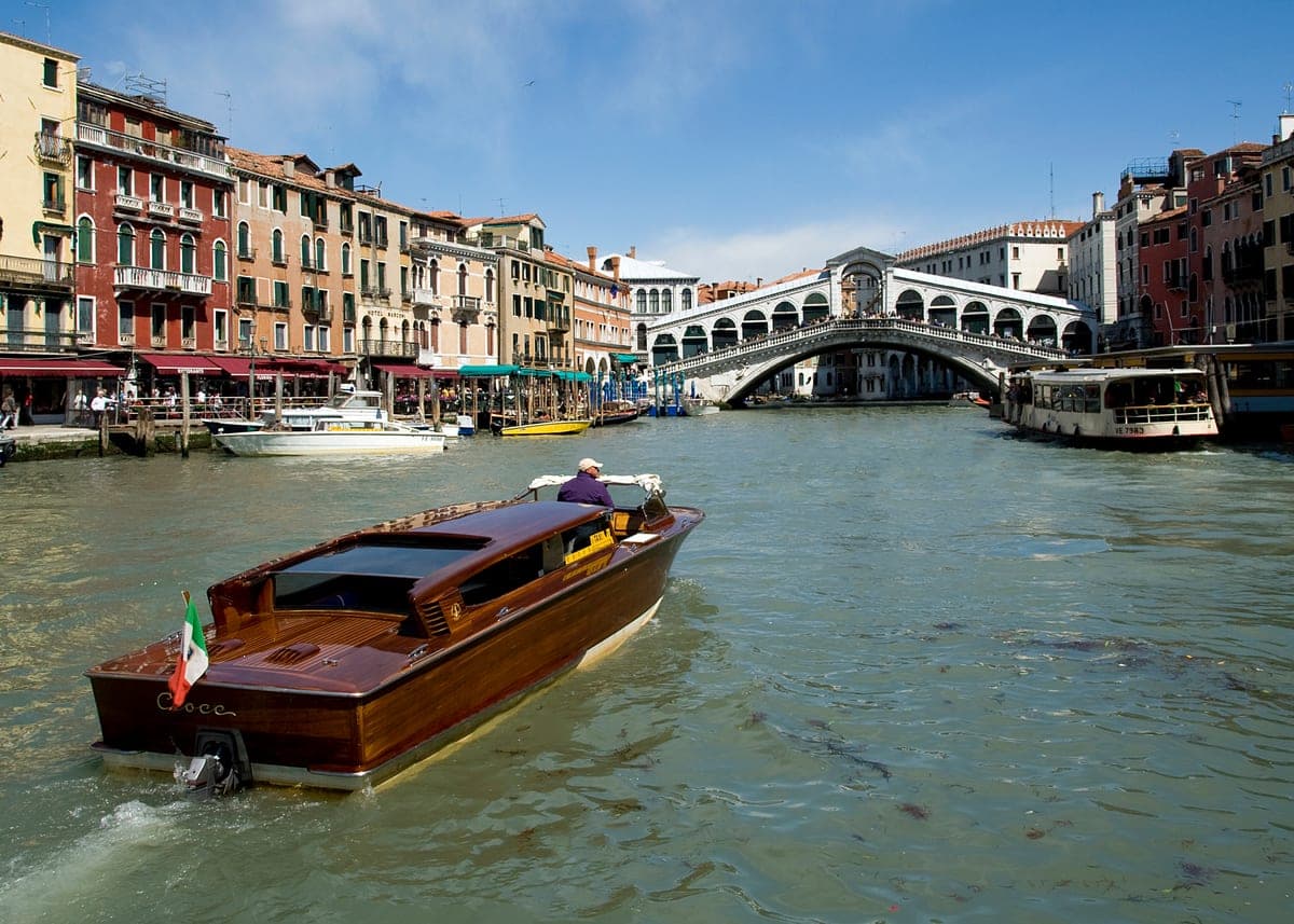 Podul Rialto peste Canal Grande, cu gondole pe apă.